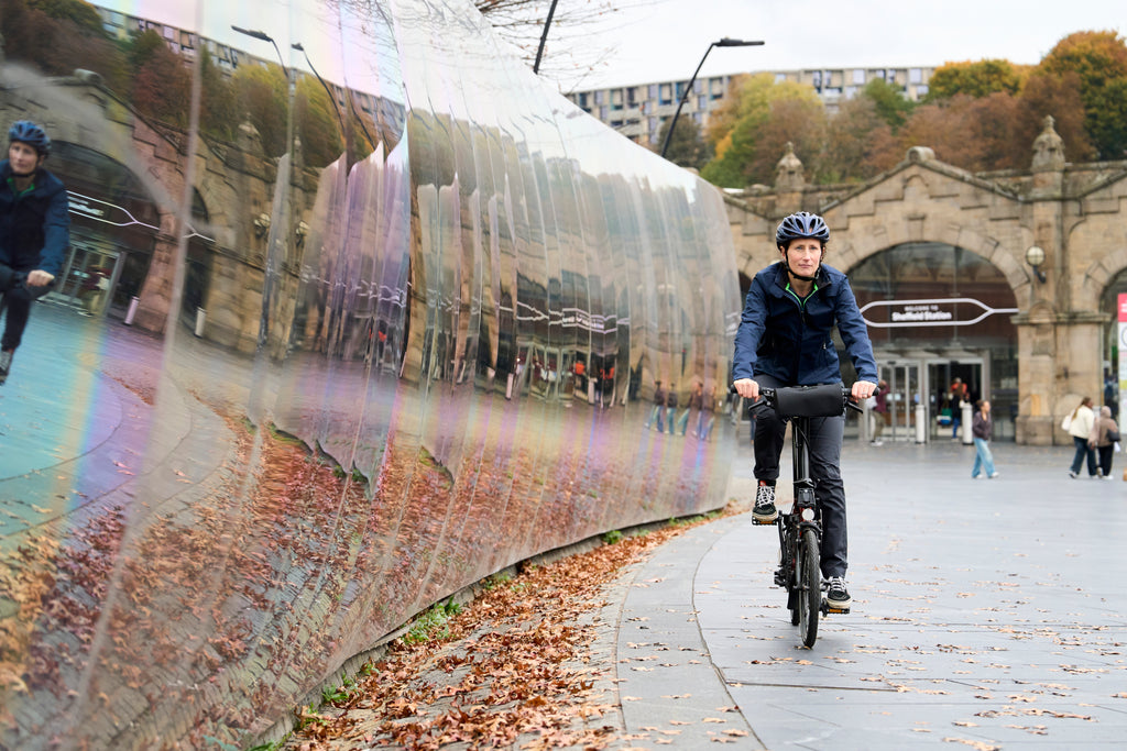 Woman cycling in a Harrington jacket